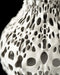 Futuristic home decor vase showcasing fluid curves and clustered negative space, expertly printed using sustainable 3D technology; the honeycomb-like perforations twist along the form, producing contrast between solid material and voids; suitable for dried flowers, decorative stems, or curated floral arrangements; this unique home accent doubles as a sculptural centerpiece.
