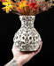 Spherical vase with dramatically sculpted openwork that reveals interior depth through dozens of curved and elliptical perforations; faint horizontal 3D-print striations add character to the smooth matte finish; ideal for dried flowers, decorative stems, or curated floral arrangements; the piece balances complexity and simplicity with a touch of mathematical symmetry.