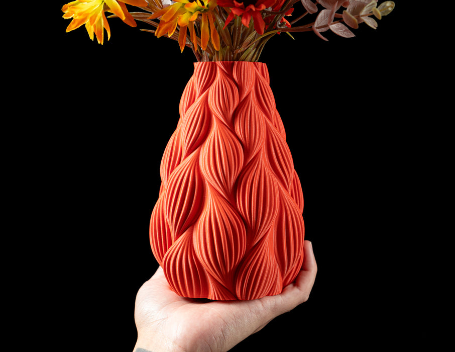 angled view of red-orange vase with flame-like textured body and narrow top opening, perfect for decorative dried flowers