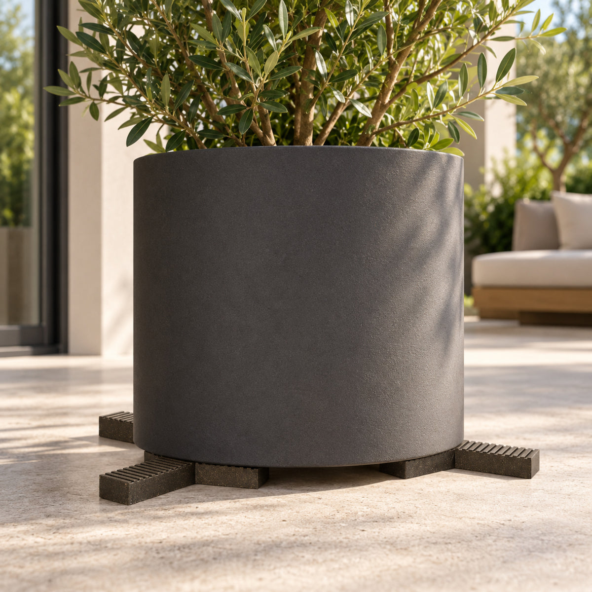 Outdoor planter supported by three separate Trivio pot feet on a contemporary patio.