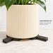 Close-up of a planter lifted slightly above a stone surface on separate Trivio plant pot feet.