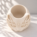 Top view of an empty cream white cat planter showing its open planting cavity and solid inner floor