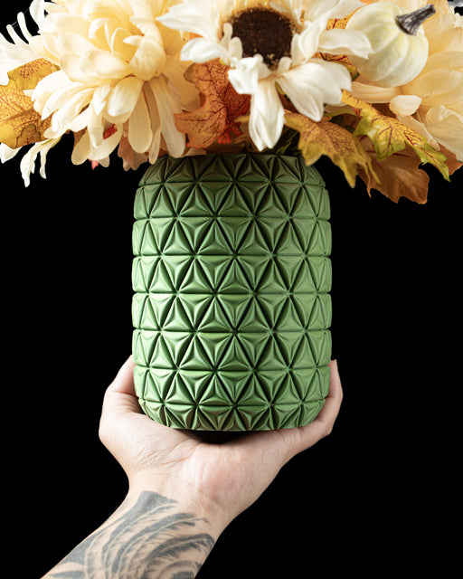 green 3d printed flower vase with vertically interlaced ribbon-like bands creating an intricate braided texture, modern vase design for dried flowers or ikebana, miniature size, suitable for home office decor, unique personalized vase gift with sculptural appeal and aesthetic matte finish