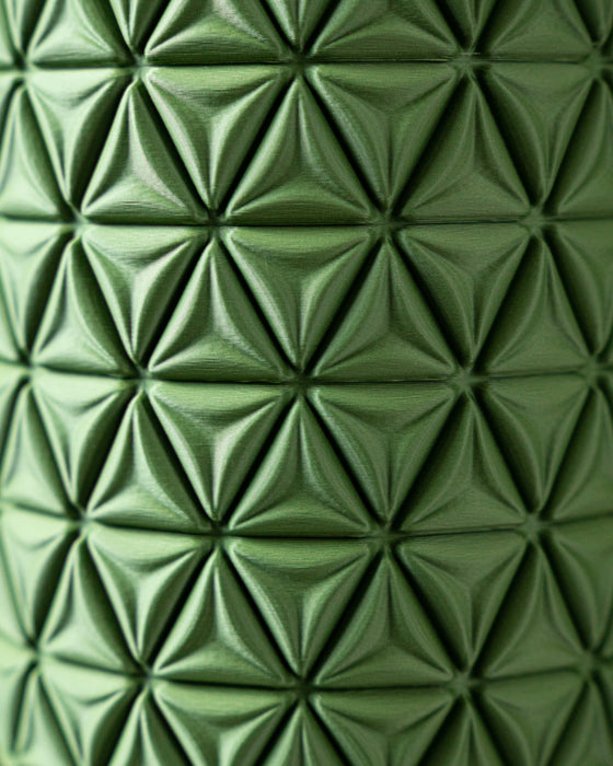 perspective shot of green sculptural vase with tightly looped vertical bands, miniature flower vase design with organic curves, personalized home decor piece ideal for ikebana and unique gift ideas