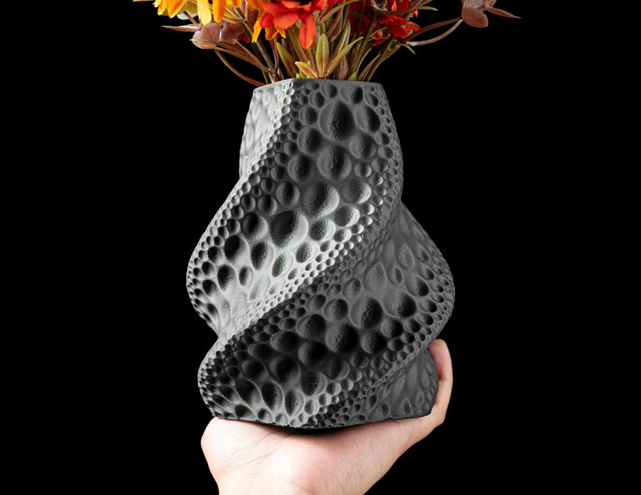 flower vase in deep black with subtle lunar crater pattern, black vase featuring curved profile and wavy concave detailing, 3d printed vase ideal for dried flowers and sculptural compositions, modern vase with bold shadow play and vertical indentations, personalized vase for stylish home office decor, unique gift for design lovers, home office decor accent with artistic moon-inspired shape, aesthetic vase with complex curvature and cratered relief, black sculptural vase for flowers or ikebana, vases for flo
