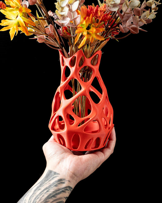 close-up of 3d printed orange vase with open mesh pattern and sculpted peaks, modern vase with coral-like architecture and perforated curves, aesthetic vase for dried flowers or decorative stems, vases for flowers with smooth parametric flow and bold minimalism, personalized vase with expressive organic geometry