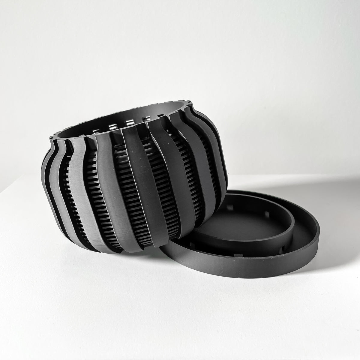 Avix ventilated orchid pot with rounded ribs, angled view beside separate tray