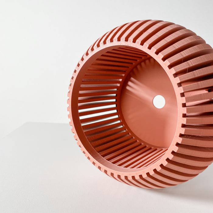 Top view of a 3D printed peach-colored orchid pot with ribbed texture, featuring a drainage hole and matching tray. Perfect for orchids, it offers a modern look and optimal care for your plants.