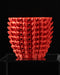 Modern red planter pot displayed on dark backdrop, eye-catching designer pot for small plants