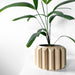 Modern cylindrical plant pot with continuous sculptural ridges wrapping vertically, viewed at a three-quarter angle