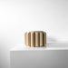 Sculptural flower pot with elongated vertical ridges forming rhythmic pattern on a cylindrical body, shown in side view