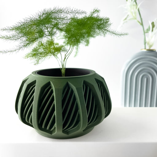 Green 3D printed planter pot with twisted ribbon-like structure and wide round opening – shown with plant