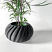 Bold black flower pot with vertical ripple design, 3D printed for futuristic decor and plant lovers