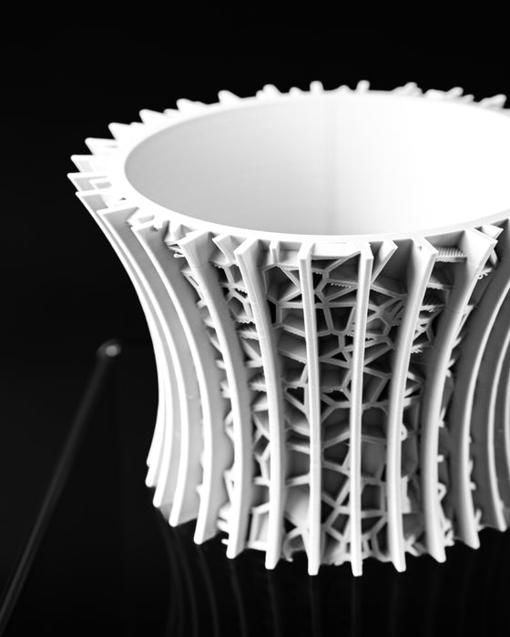 Vora openwork planter close-up showing curved ribs and geometric cross-bracing