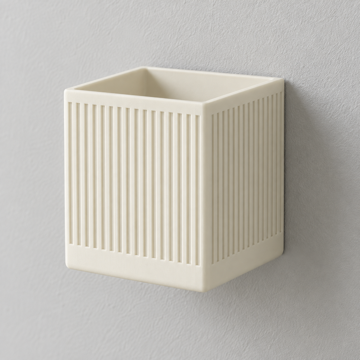 Empty cream Linor square wall planter with fine vertical ribs mounted on a pale wall.