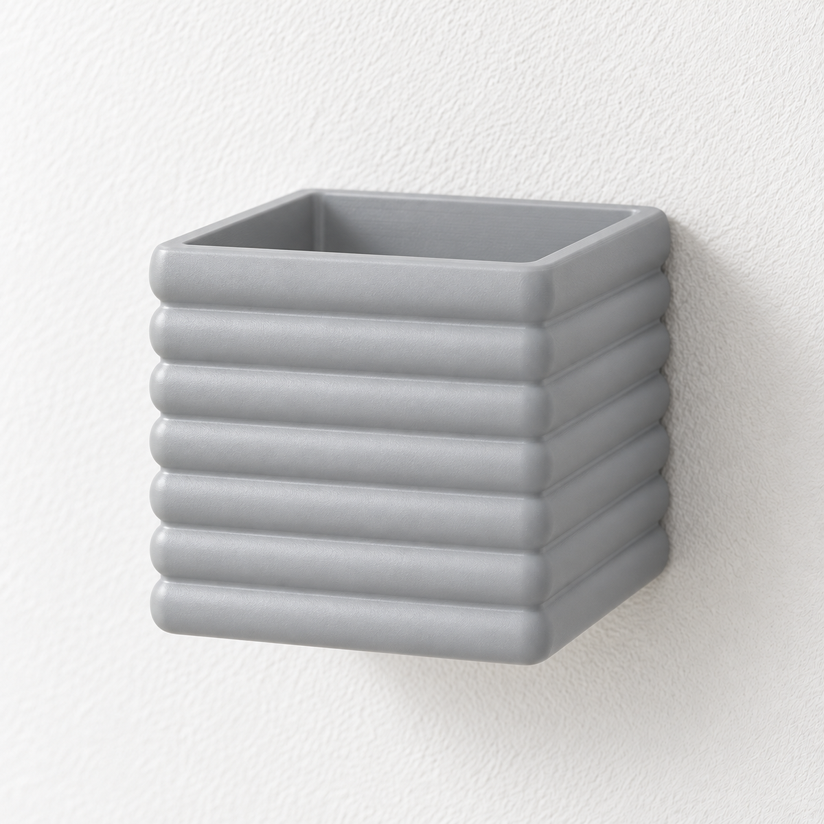 Empty gray Seno square wall planter with broad horizontal ribs, mounted on a pale wall.