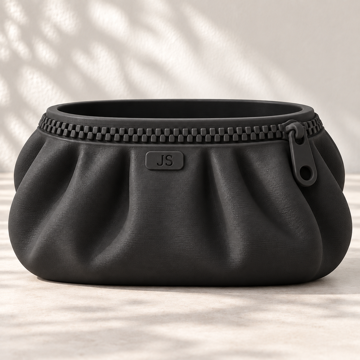 Black Zipra pouch planter with JS initials, front plaque and sculpted folds