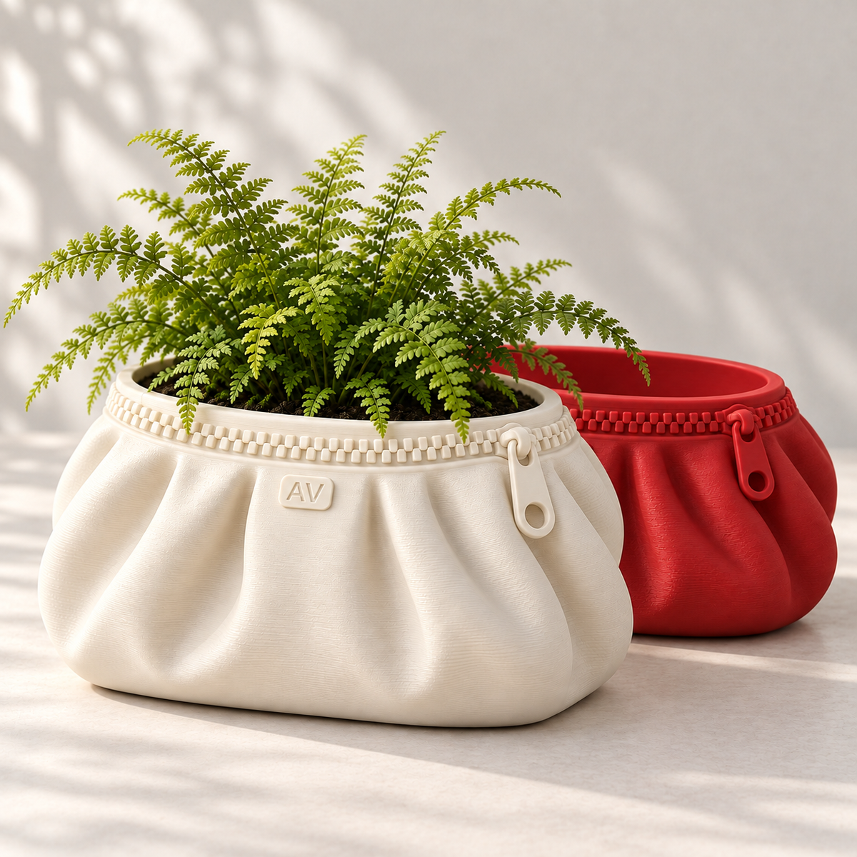 Ivory Large Zipra pouch planter with AV initials and fern in front of red Medium planter; indoor styling, one planter per order